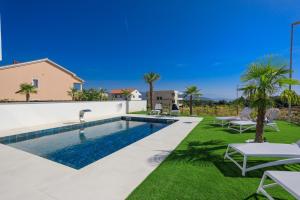a swimming pool in a backyard with lawn chairs and a villa at Lea Magdalena Iii in Krk