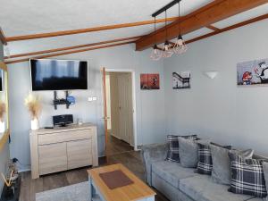 ein Wohnzimmer mit einem Sofa und einem Flachbild-TV in der Unterkunft Dog Friendly 8 Berth Lodge, 600 Yard's From The Beach In Hunstanton in Hunstanton