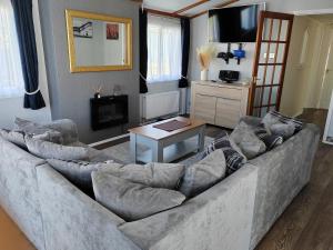 uma sala de estar com um sofá grande e uma mesa em Dog Friendly 8 Berth Lodge, 600 Yard's From The Beach In Hunstanton em Hunstanton