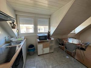 a small kitchen with a sink and a table at Duplex F2 - proche GARE TGV in Mulhouse +9 photos