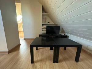 a black table with a computer on it in a room at Duplex F2 - proche GARE TGV in Mulhouse