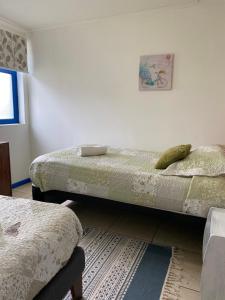 um quarto com 2 camas individuais e um tapete em Lodging Incógnita, Punta Arenas em Punta Arenas