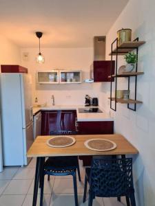 La cuisine est équipée d'une table, de chaises et d'un réfrigérateur. dans l'établissement Aera, à Nice
