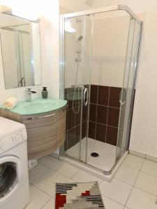 La salle de bains est pourvue d'une douche, d'un lavabo et d'un lave-linge. dans l'établissement Aera, à Nice