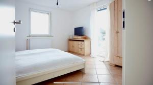 ein Schlafzimmer mit einem Bett und einem TV auf einer Kommode in der Unterkunft Ferienwohnung Tannen-Apotheke Eins in Mengerskirchen