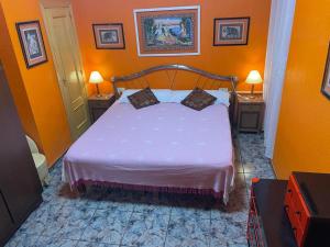 1 dormitorio con 1 cama con 2 mesas y 2 lámparas en Broadway es Mar, en El Perelló