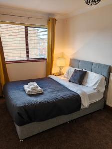 a bedroom with a bed with a towel on it at Heads on Bed Pitsea Basildon Essex House with Free Parking Netflix & Wifi in Basildon