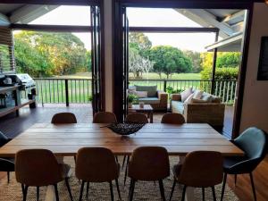 uma mesa de madeira e cadeiras numa sala de estar em A place to relax em Mudjimba