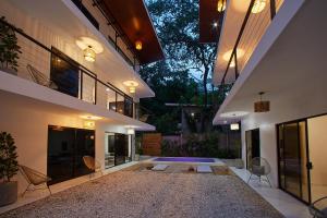 a courtyard of a house with chairs and a building at Deluxe Loft 1 BDR con linda vista in Puntarenas