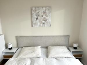 a bedroom with a white bed with two night stands at ENDLESS: Zentrumsnah, 5min zum See + Stellplatz in Schwerin