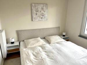 a white bed with two pillows in a bedroom at ENDLESS: Zentrumsnah, 5min zum See + Stellplatz in Schwerin