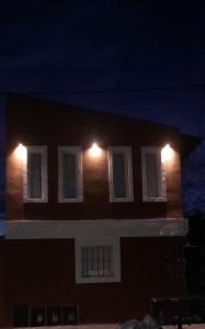 a building with lights on the side of it at night at Alojamiento walter in Ezeiza