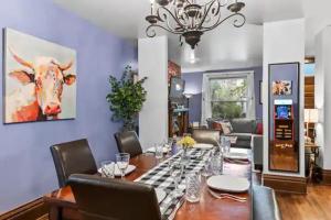 a dining room with a table and a cow painting on the wall at Luxury Retreat: Villa Haven for Your Perfect Holiday in Denver
