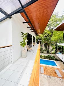 un patio al aire libre con techo de madera y piscina en Deluxe Loft 1 BDR con linda vista, en Puntarenas