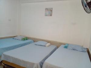 two beds in a room with blue sheets at Hostal Santa Marta in La Unión