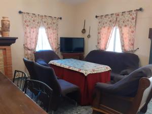 - un salon avec une table, des chaises et une télévision dans l'établissement Alojamiento Rural VillaSol, à La Piedra de la Sal