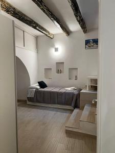 a bedroom with a bed in a white room at Vicolo Garibaldi in Tropea