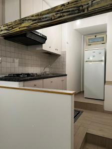 a kitchen with white cabinets and a white refrigerator at Vicolo Garibaldi in Tropea +22 photos