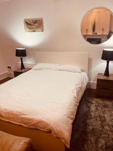 1 dormitorio con cama blanca y espejo en Modern Large Studio en Londres
