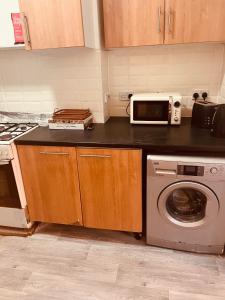 cocina con microondas, lavadora y horno en Modern Large Studio en Londres