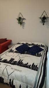 a bedroom with a bed with a black and white comforter at Appartement jolie vue WIFI in Besançon