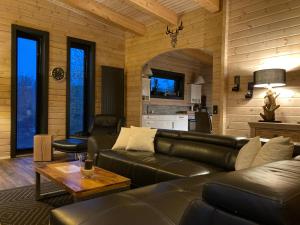 a living room with a leather couch and a table at Blockhaus Kik im Harz in Sankt Andreasberg