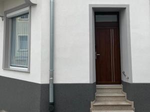 a building with a door and stairs in front of it at Apartament na Wodnej in Głogówek