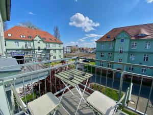 einen Balkon mit Stühlen und einem Tisch sowie einige Gebäude in der Unterkunft Design Apartment / 1 Room / Netflix / Parken in Magdeburg