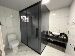 y baño con ducha, aseo y lavamanos. en Hotel e Cabanas Perau QUARTOS, en Ametista do Sul