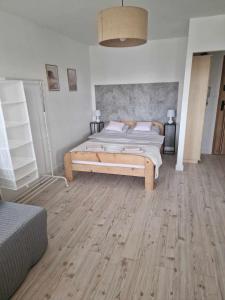 a bedroom with a bed and a wooden floor at Apartament Gryfice in Gryfice