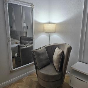 ein Wohnzimmer mit einem Stuhl und einem Spiegel in der Unterkunft Apartament M2 Vatra Dornei in Vatra Dornei