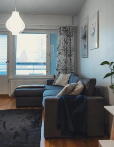 a living room with a couch and a window at Aurora Breeze Residence - City Center in Rovaniemi