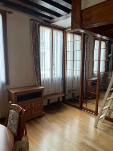 Il comprend un salon doté de parquet, de fenêtres et d'une table. dans l'établissement Quatre rêves à Lutèce, à Paris