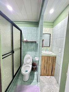 a bathroom with a toilet and a sink at Caribbean View House in Tortuguero