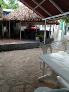 un patio con tavolo, sedie e griglia di HOTEL GUATAQUI PUERTO PRINCIPAL a Guataquí