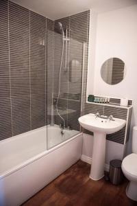 a bathroom with a sink and a tub and a toilet at Buttercup House in Saint Neots