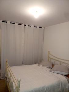 ボンディにあるAppartement jardin proche Parisのベッドルーム(白いカーテン付きのベッド1台付)