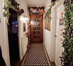 um corredor com uma porta e um piso de azulejo em La cachette sous l'escalier, le gîte ensorcelé 
