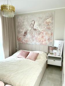 1 dormitorio con 1 cama con una pintura en la pared en LuxApart Apartamenty Jantar en Jantar