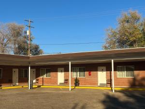 a brick building with a parking lot in front of it at DeLano Motel & RV Park Beaver in Beaver
