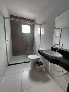 聖克魯斯－卡布拉利亞的住宿－Casa individual com piscina e area gurmet，浴室配有卫生间、盥洗盆和淋浴。