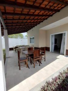 een patio met een houten plafond en een tafel en stoelen bij Casa individual com piscina e area gurmet in Santa Cruz Cabrália