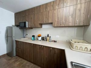 a kitchen with wooden cabinets and a refrigerator at Big apartment near historical center in Arequipa
