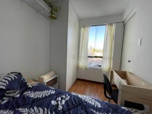 a bedroom with a bed and a desk and a window at Big apartment near historical center in Arequipa