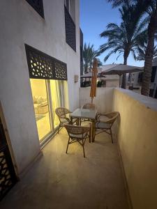 eine Terrasse mit einem Tisch, Stühlen und einem Fenster in der Unterkunft Scarab ES 03 GF One Bedroom Gouna in Hurghada