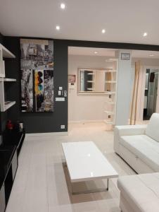 een woonkamer met een witte bank en een tafel bij APARTAMENTO COLON GARAJE Gratuito in Logroño