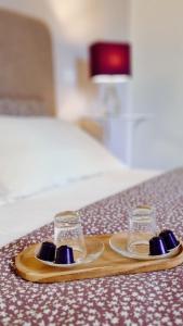 a pair of glasses on a wooden tray on a bed at Dimora Montecchi in Verona