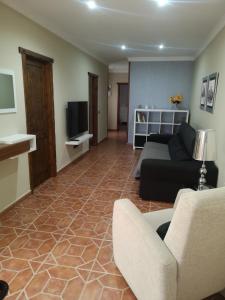 een woonkamer met een bank en een tv bij La casa de Rei in Sardina