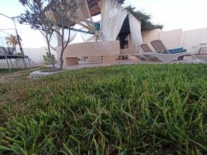 un par de sillas sentadas al lado de una casa en Magnifique villa avec piscine, en Djerba