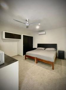 1 dormitorio con 1 cama y ventilador de techo en Casa Creunza de Mar en Playa del Carmen